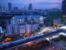 Panoramic cityscape from a high-rise building at dusk with urban skyline and transportation infrastructure