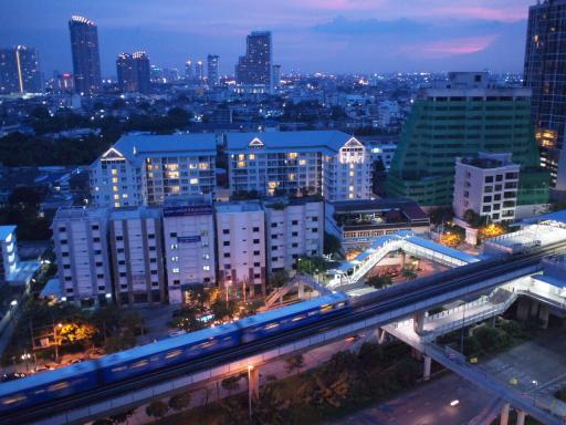 Panoramic cityscape from a high-rise building at dusk with urban skyline and transportation infrastructure