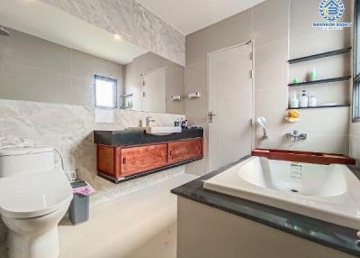 Modern bathroom with wooden vanity and marble tiles