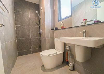Modern bathroom with wall-mounted fixtures and grey tiling