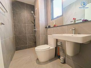 Modern bathroom with wall-mounted fixtures and grey tiling