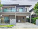 Modern two-story house with a spacious driveway and balcony