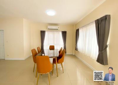 Spacious and well-lit dining room with modern furniture and an air conditioning unit