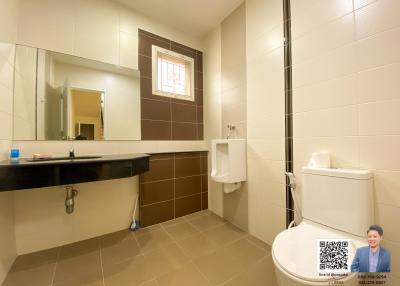Spacious modern bathroom with wide mirror and tiled walls
