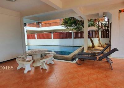 Spacious covered patio area with swimming pool view