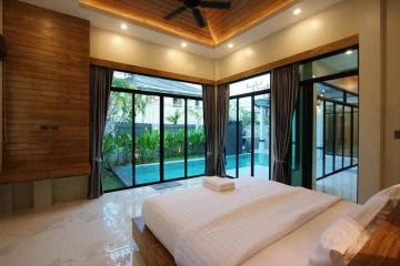 Modern bedroom with large windows overlooking a pool