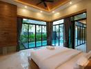 Modern bedroom with large windows overlooking a pool