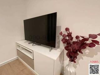 Modern living room with a large flat-screen TV and decorative vase