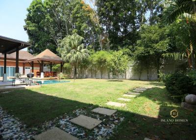 Spacious backyard with pool and lush greenery