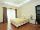 Spacious bedroom with a large bed, hardwood floors, and ample natural light