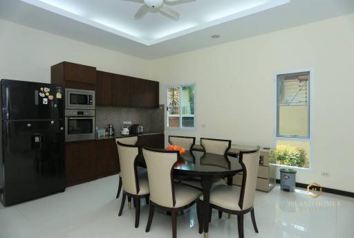 Modern kitchen with dining area, fully equipped with stainless steel appliances