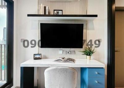 Modern home office with desk and chair, large TV or monitor, and air conditioning unit
