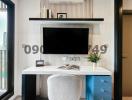 Modern home office with desk and chair, large TV or monitor, and air conditioning unit