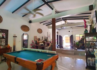 Spacious and well-furnished living room with pool table and high ceiling