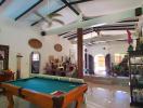 Spacious and well-furnished living room with pool table and high ceiling