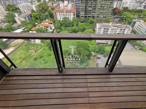 Spacious balcony with wooden flooring overlooking urban landscape