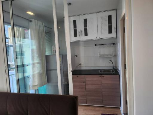 Modern compact kitchen adjacent to living area with natural light