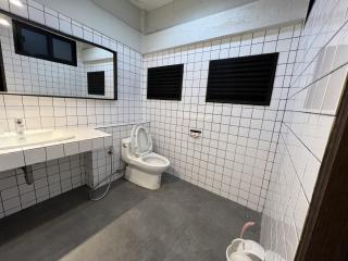 Modern bathroom with white tiling, wall-mounted sink, and toilet