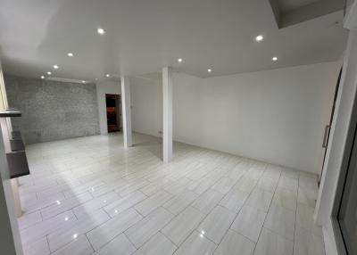 Spacious, well-lit empty interior space with white tiles and modern design