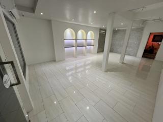 Spacious and modern interior of a building with white tile flooring and elegant lighting