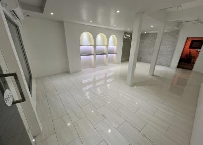 Spacious and modern interior of a building with white tile flooring and elegant lighting
