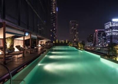 Elegant rooftop pool overlooking city skyline at night