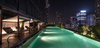 Elegant rooftop pool overlooking city skyline at night