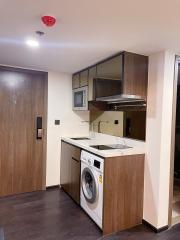 Compact kitchen with modern appliances and wood finish