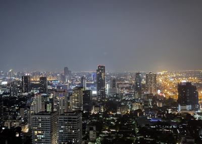 Aerial night view of a cityscape with illuminated buildings