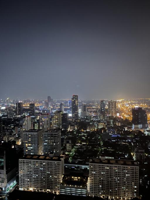 Aerial night view of a cityscape with illuminated buildings