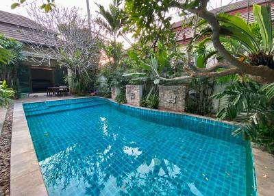 Spacious backyard with a large swimming pool and lush greenery