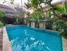 Spacious backyard with a large swimming pool and lush greenery