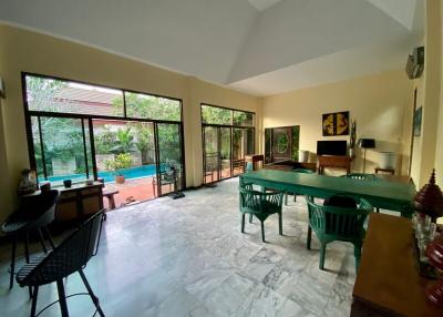 Spacious living room with high ceilings and pool view