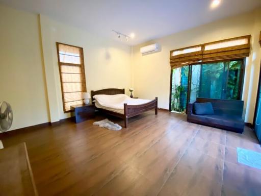 Spacious bedroom with natural light and a view of greenery