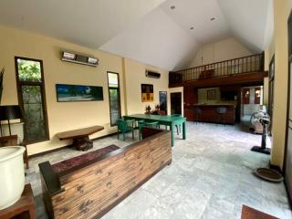 Spacious living room with high ceiling, natural light, and open floor plan