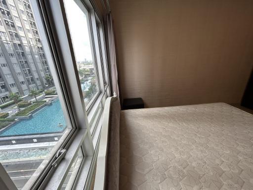 Spacious bedroom with a large window overlooking the swimming pool