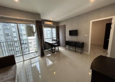 Spacious and well-lit living room with modern furnishings and balcony access