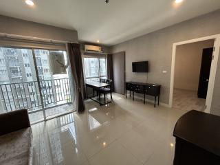 Spacious and well-lit living room with modern furnishings and balcony access