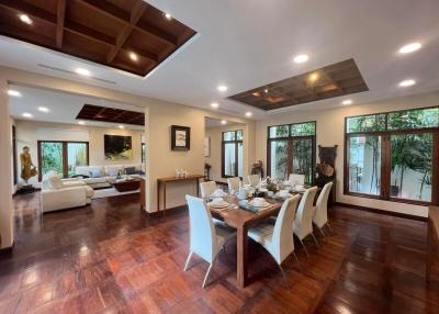 Elegant open-plan living and dining area with wooden flooring and ample natural light