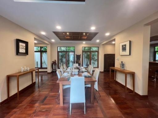 Spacious dining room with elegant wooden flooring, a large dining table set, and great natural lighting
