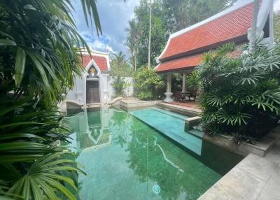 Serene outdoor pool area with lush greenery and traditional architectural elements