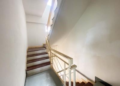 Interior staircase with white walls and handrail
