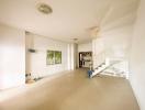 Spacious unfurnished living room with staircase and large window