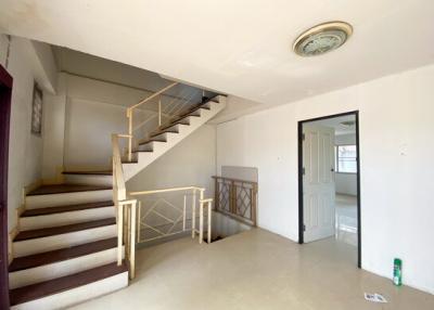 Interior view showing a staircase with railing and tiled flooring