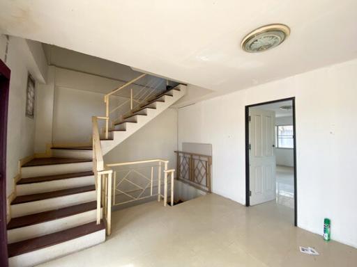 Interior view showing a staircase with railing and tiled flooring