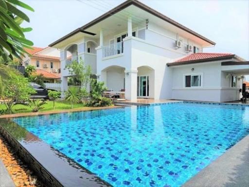 Luxurious two-story house with a large swimming pool and tropical landscaping