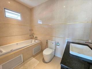 Modern bathroom with bathtub and neutral tiles