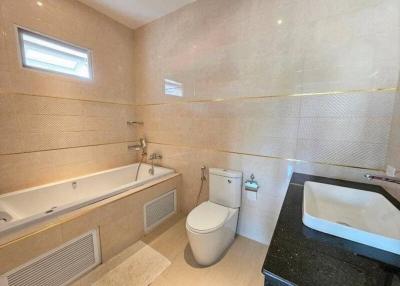 Modern bathroom with bathtub and neutral tiles