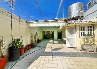 Spacious outdoor courtyard with potted plants and water tank