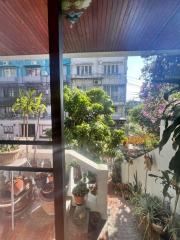 Cozy balcony overlooking greenery and neighboring buildings